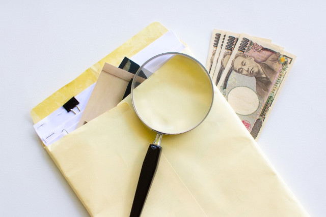 お金と書類と虫眼鏡